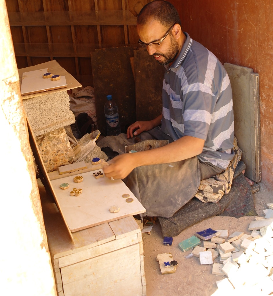 Artisan working with hand crafted tiles at the Tombeaux Saadiens